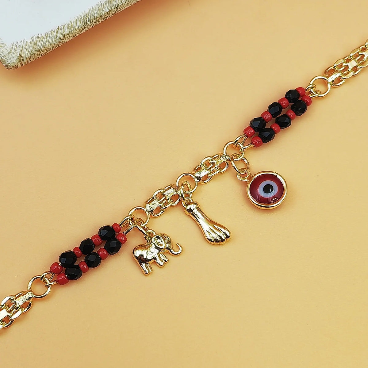 Gold-Tone Chain Bracelet with Red and Black Beads, Elephant Charm, Feather Pendant, and Round Stone Accent – 19 cm Length - Image 3